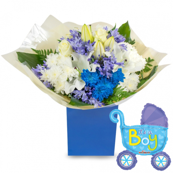 A compact, joyful arrangement presented in a deep royal-blue rectangular gift box, the display feels like a little ceremony in miniature-white and blue in perfect balance. Central white roses provide a soft, familiar elegance, surrounded by partially opened white lilies whose slender buds promise new beginnings; plush white chrysanthemums add a voluminous, comforting texture. Striking clusters of electric blue chrysanthemums punctuate the composition, their vivid hue echoing the celebratory motif, while delicate sprigs of lavender or periwinkle hyacinth-like blooms weave through the larger flowers, lending subtle scent and fine detail. Rich green foliage-glossy leaves and delicate fern fronds-frames the bouquet and enhances the contrast between cool blues and creamy whites. The stems are gathered in crinkled, translucent cream paper that gives a handcrafted feel and tucks neatly into the matte box. Beside the flowers, a light-blue foil balloon in the shape of a vintage baby carriage adds movement and charm; darker-blue highlights on the canopy and wheels, dotted with tiny polka dots and heart designs, catch the light, and the phrase It's a Boy appears across the carriage in playful yellow and lime-green lettering.

This piece reads as both a practical gift and a sentimental keepsake, ideal for a hospital bedside or an afternoon visit to a new family in Mill Hill Village or along The Ridgeway. The textures-silky petals, papery wrap, shiny balloon-translate into a warm, tactile experience, while the colour story conveys calm celebration and quiet delight at the arrival of a newborn son.