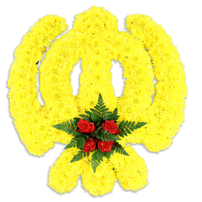 An emblematic Khanda rendered entirely from bright yellow chrysanthemum blooms occupies the frame, set against an uncluttered white background that accentuates the arrangement's sculptural clarity. Thousands of small chrysanthemum florets are packed close to one another, their golden petals overlapping so the emblem's components - the circular chakkar, the vertical double-edged khanda and the twin crossed kirpans - read as a single luminous form with subtle surface relief. The texture is soft and dense, like a cushion of sunshine, but the silhouette remains disciplined and exact, echoing the symbol's spiritual and martial meanings. At the emblem's centre a compact bouquet of five to six deep red roses provides a solemn, elegant focal point; their velvety petals sit amid a framing collar of dark green fern fronds whose fine blades add depth and a cool tonal counterpoint. A gentle shadow beneath the piece confirms its physical presence as a standalone wreath or display suitable for a funeral, memorial service or Sikh cultural ceremony. The arrangement suggests a discreet floral perfume - chrysanthemum sweetness undercut by the richer, more resonant scent of roses - and is crafted with the care expected of an experienced local florist serving Mill Hill, Mill Hill Broadway and the surrounding Brent Cross area. Its visual honesty and traditional palette offer comfort and respect: a considered floral tribute that speaks of remembrance, faith and communal care.