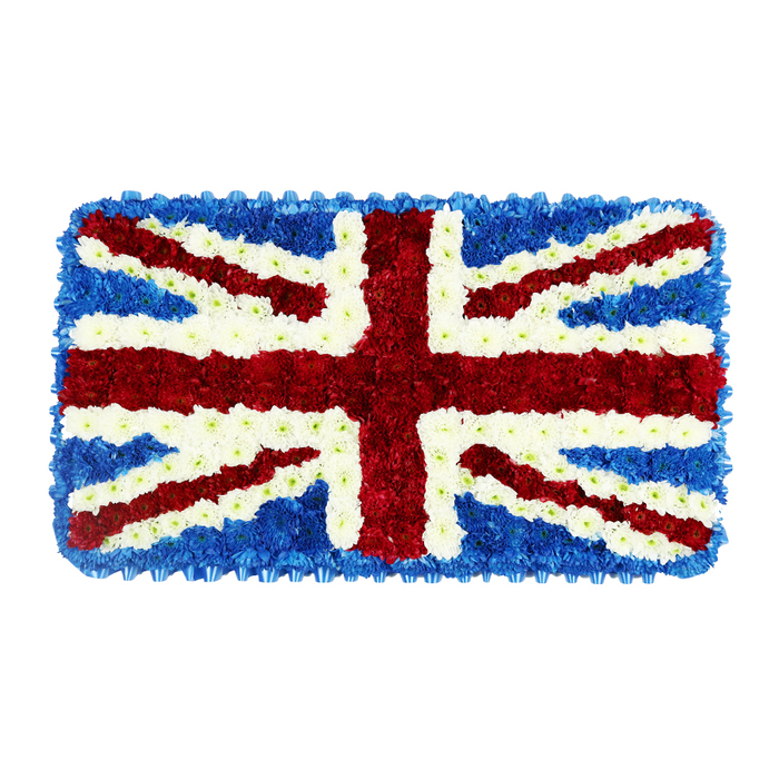 Here, a patriotic funeral tribute is captured in the form of a rectangular floral Union Jack, painstakingly crafted from thousands of small blossoms that together create a deeply textured surface. Against a neutral white background, the colours appear especially vivid: strong reds, clear whites, and cool blues that mirror the tones of the flag while softening them through the natural softness of petals. Across the centre, a broad red St George's Cross spans top to bottom and side to side, its edges perfectly straight, formed from densely packed flowers that give the lines a sense of weight and permanence. Each red band is flanked by crisp white stripes of blooms, the careful fimbriation ensuring that the red never bleeds into the surrounding blue areas. From the corners of the tribute, diagonal red bands of St Patrick's Cross cut across the surface, again outlined in fine white floral strips laid over the wider white diagonals of St Andrew's Cross beneath, giving a layered, almost sculpted depth to what is, in reality, a flat arrangement. The remaining spaces and the tidy border are filled with dark blue florets, clustered close to create a velvety, even background reminiscent of twilight over Mill Hill's rolling edges and distant views. Every flower head is aligned and supported, with no drooping or gaps, showing the steady skill of a professional florist. This piece is ideally suited for funerals, memorials, or national remembrance services in Mill Hill, perhaps placed beside a coffin in a chapel or at the front of a service marking military history, service to the Crown, or heartfelt British identity within the local community.