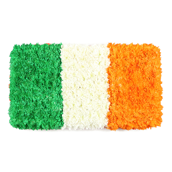 This is a contemplative, living symbol of unity and heritage. A rectangular panel of petals, three bold vertical bands of green, white, orange, arranged with the same meticulous care found in a Mill Hill studio. The green stripe is lush and dense, a field of tiny blossoms-green carnations or chrysanthemums-whose surface hints at the careful clusters of petals. The white stripe in the middle is a delicate, cloud-like band of very white petals, giving an impression of calm and clarity. The orange stripe to the right radiates warmth, matching in texture and density to its neighbours, with marigolds or orange chrysanthemums contributing their bright glow.

The white background intensifies the floral tapestry; the flag's proportions feel true to life, its craft speak to a local audience used to attention to detail. In Mill Hill, such a piece would anchor a community event, a remembrance service, or a local article on Irish culture and identity. Crafted by a seasoned local florist, it carries a sense of respect and reverence, while conveying celebration. It invites viewers to pause, to inhale the scent of fresh petals and to feel the warmth of a shared heritage.