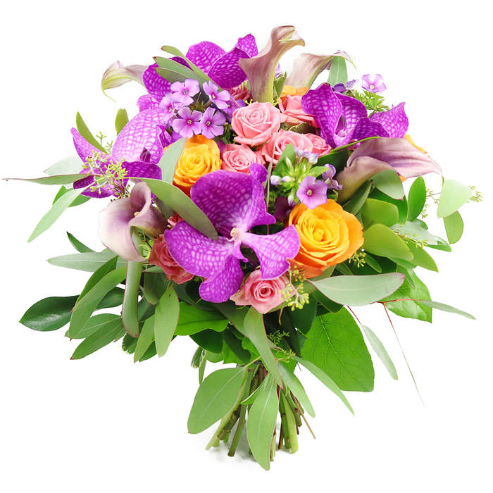 This photograph presents an abundant, carefully composed bouquet set against a pure white background, which accentuates the vibrant interplay of colour and form. Central to the design are several striking Vanda orchids, their broad petals saturated in a brilliant fuchsia-purple tone and overlaid with a distinctive speckled or netted pattern that conveys an air of exotic luxury. Surrounding these dramatic flowers are lively orange roses, their tightly coiled petals forming rounded, full blooms that glow like small lanterns and introduce a joyful brightness to the piece. Balancing this energy are softer notes of pastel and blush pink roses, scattered throughout the bouquet; some remain as small, promising buds, while others have begun to open into layered, romantic forms that soften the stronger hues. Rising elegantly from within, you can see a series of slender calla lilies in a sophisticated plum-lavender shade, their smooth, trumpet-shaped flowers curving gently and adding vertical interest and a sculptural flair. The bouquet sits in a lush cradle of greenery, featuring elongated, silvery eucalyptus foliage and darker, more compact leaves that build depth, contrast, and a refreshing, garden-like feeling reminiscent of quiet corners of Mill Hill Park or the leafy streets around Lawrence Street. Delicate clusters of tiny lavender and lilac filler flowers are tucked between the larger blooms, lending a fine, intricate texture that rewards close attention. The stems below are visible and neatly bound, marking this as a professional, hand-tied creation. With its rich palette of purple, orange, pink, and green, this bouquet feels both celebratory and refined, perfect for marking special occasions, enhancing an elegant home in Mill Hill, or illustrating premium floristry available for local delivery.