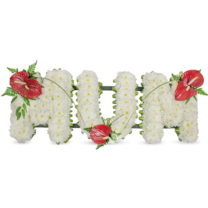 A poignant floral tribute that spells MUM in large, elegant capitals, presented against a crisp white background to showcase the craftsmanship involved. Each letter is entirely covered with hundreds of small white spray chrysanthemums, densely packed to create a seamless, pillowed surface that suggests purity and calm. The dense white blooms float above a subtle dark green framework visible only where the arrangement's edges taper, providing discreet structural support and a gentle outline. Three striking red anthuriums provide focal warmth-their glossy, heart-shaped spathes and pale yellow spadices distinct-positioned with careful balance: one on the top left curve of the first 'M', another nestled into the lower curve of the 'U', and the final bloom placed on the top right of the last 'M'. Around each anthurium, clusters of deep green foliage, including feathered fern fronds and broader leaves, create pockets of shadow and texture that enrich the white field. Long, arching blades of grass or slender stems sweep across the letters, visually tying the red accents together and lending a graceful movement to the composition. The lighting is soft and even, as if near a north-facing window in a Mill Hill parlor, which highlights the chrysanthemums' matte softness against the anthuriums' polished sheen. This is a classical sympathy piece, carefully designed for wakes, funeral services or graveside memorials, offering a dignified, loving tribute to a mother and a contemplative presence for grieving families across Mill Hill and nearby streets.