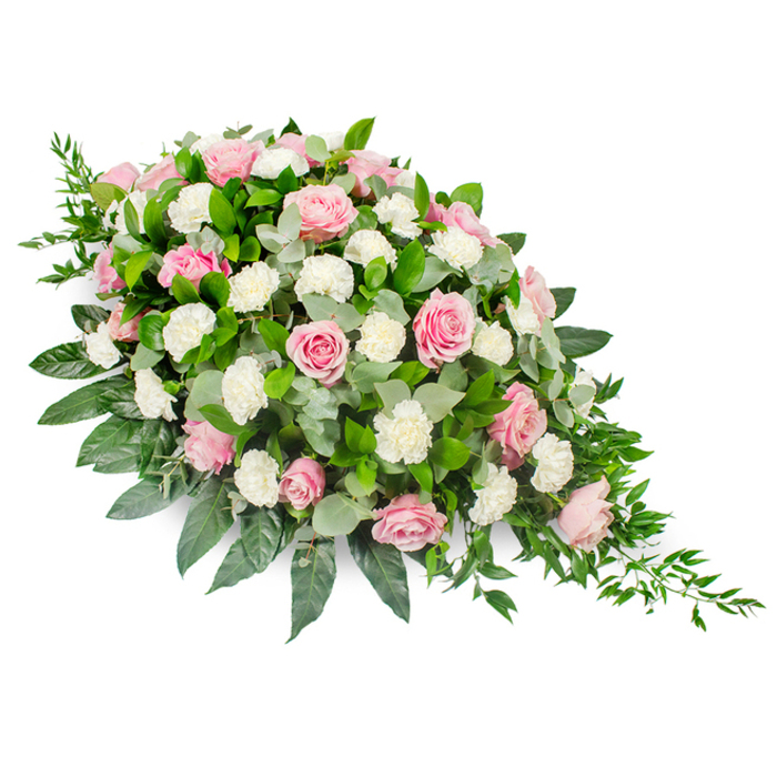 This image shows a substantial, traditional funeral spray arranged in a classic elongated teardrop shape, resting against a stark white studio background so every petal and leaf can be clearly appreciated. The upper left portion of the arrangement is full and rounded, gradually narrowing down to a delicate, tapered tip at the lower right, reminiscent of a single gentle tear. Soft pink roses dominate the composition, their shades ranging from the faintest blush to richer rose tones, and their forms varying from tight buds to wide-open blossoms. These roses are interlaced with clusters of fluffy white carnations and spray carnations, their intricate, frilled petals providing a plush contrast to the smoother rose blooms. The interplay of pink and white creates a tender, comforting palette, perfectly suited to express sympathy and remembrance at services in Mill Hill's local churches or crematoriums. Underpinning the flowers is a foundation of abundant greenery: broad, glossy dark green leaves, likely salal or camellia, extend outward to give the piece its generous outline, while rounded sprigs of silvery-green eucalyptus tuck between blooms, adding softness, texture, and a subtle sense of cool freshness. Along the slimmer edge of the design, dainty strands of trailing ruscus stream outward, creating a cascading effect that enhances the sense of natural flow. The overall impression is of a carefully crafted tribute, elegant yet understated, as if thoughtfully prepared for a family gathering after a quiet walk across Mill Hill Park or from Mill Hill Broadway. This floral spray serves as a beautiful, respectful way to honour a loved one's memory, surrounding them with delicate colour and lush foliage at a final farewell.
