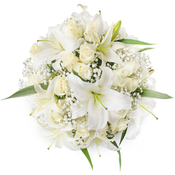 From an overhead viewpoint this compact circular bouquet reads as a study in whites and creams, each bloom deliberately placed to create a harmonious, symmetrical whole against a pristine white background. Prominent white oriental lilies open wide, their smooth, trumpet-shaped petals curving outward to reveal pale green stamens and a faint dusting of pollen that gives natural contrast and visual interest. Nestled between and beneath the lilies are many cream and ivory roses, most in tight bud or partially opened to display the soft, layered spirals of their petals; these add a plush, almost tactile quality to the arrangement. Scattered throughout like drifting clouds are fine sprays of Baby's Breath (Gypsophila), whose miniature white florets lend an airy, lace-like texture that lightens the bouquet's visual weight. Around the edges a few vivid green leaves peek out, their glossy surfaces and clean lines framing the circular shape with a fresh counterpoint to the all-white palette. The even, soft lighting highlights the subtle tonal differences and invites an imagined scent of sweet roses mingled with the delicate perfume of lilies. This arrangement suggests timeless elegance - perfect for bridal bouquets, sophisticated table centrepieces, or consoling floral tributes - and reflects floral preferences common to ceremonies and celebrations held in and around Mill Hill Village and Bittacy Hill, where classic white blooms are often chosen to mark both joyful and solemn moments with dignity and grace.