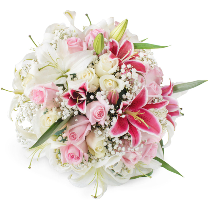 The photograph presents a sumptuous floral bouquet from a gently elevated viewpoint, set against an immaculate white background that accentuates its colours and refined shape. The design is lush and rounded, with no visible gaps, creating the impression of a continuous sea of petals. Prominently featured are several large white lilies, some in full, open bloom with trumpet-shaped petals extending outwards, others still tightly held as green buds that promise future blossoms. Around these lilies, roses in soft blush pink and creamy white are woven carefully, each one selected for its shape and stage of opening. Some roses are small, tight buds with just the hint of colour at the centre, while others are richly open, revealing layered, velvety petals that catch light in subtle highlights and shadows. Interrupting the pastel calm are deep pink Oriental lilies, in a saturated fuchsia or magenta shade, their petals adorned with darker speckles and framing bright yellow anthers dusted with pollen. Wisps of white baby's breath flow throughout the bouquet, adding a gossamer-like texture that softens the transition between the more substantial flowers and gives the arrangement an airy, romantic feel. Slender green leaves and stems peek out in places, evoking the natural charm of Mill Hill's leafy streets and nearby Totteridge Valley. The lighting is bright yet diffused, allowing the delicate tonal shifts in each flower to show without overwhelming contrast. Altogether, the bouquet radiates warmth, affection, and celebration, ideal for gracing a Mill Hill dining table, marking an engagement, or arriving as a same-day delivery from Flowers Mill Hill to bring comfort or joy to family and friends throughout the neighbourhood.