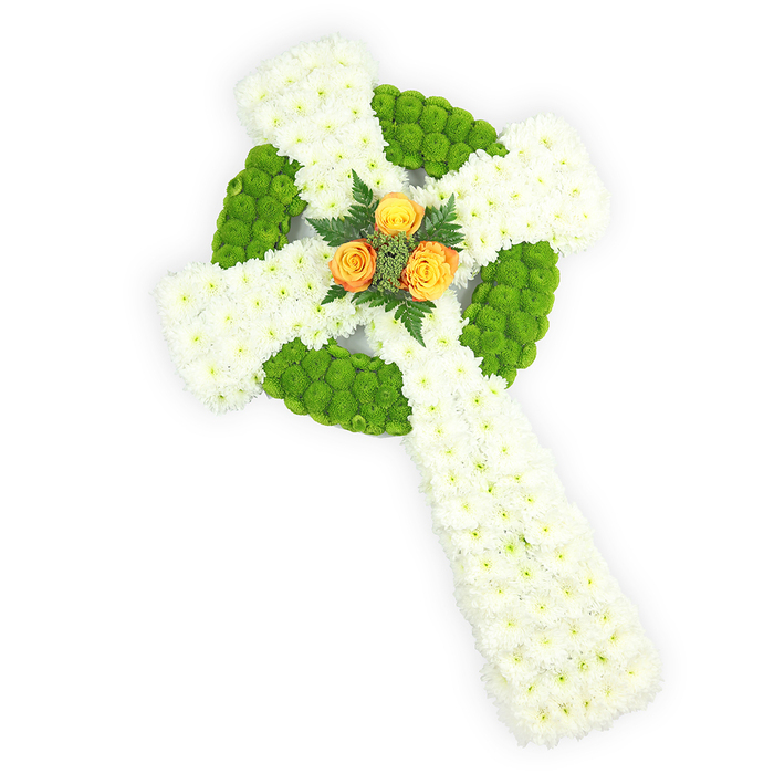An elegant, three-dimensional Celtic cross of fresh flowers captured from a slightly raised viewpoint on a bright white background, where every petal and colour shift is visible. The main body is composed of tightly packed white spray chrysanthemums whose soft, feathery heads form a plush, nearly sculptural surface across the vertical shaft and horizontal arms. Threaded through that white canvas are vivid apple-green button chrysanthemums-small, rounded blossoms that delineate the circular ring at the intersection and appear in alternating segments along the arms, creating a rhythmic, knot-like pattern that pays homage to Celtic design. At the very core of the cross three vibrant orange-yellow roses make a warm centrepiece; their fuller petals glow like embers against the cool whites and greens, and are gently cradled by darker green fern fronds that add contrast and a whisper of foliage scent. The arrangement's three-dimensionality is emphasized by soft, directional lighting that reveals shadowed recesses between the blooms and highlights the careful, handwired construction characteristic of professional funeral tributes. The colourway-white, green, and orange-naturally suggests Irish connections, making this piece especially meaningful for memorials that honour Irish heritage. As a florist who knows Mill Hill's quiet streets, I can see this placed with reverence at a service near The Ridgeway or delivered to a family meeting at Mill Hill Village, communicating solace, respect, and a crafted attention to detail that comforts those who must say goodbye.