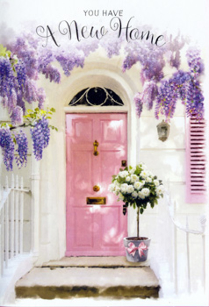 This image portrays a tender, storybook-like doorway that could easily be found on a peaceful street in Mill Hill, dressed for the moment a new homeowner first turns the key. Above the entrance, wisteria cascades in lush garlands, its blossoms falling in long, tumbling clusters of soft lavender and pale purple. The flowers cast delicate, dappled shadows over the whitewashed walls, which appear gently textured and luminous in the daylight, reminiscent of older, character-filled houses near Mill Hill Village. In the centre, a pastel pink door anchors the composition, its hue a gentle blush that suggests warmth, kindness, and welcome. A similarly painted shutter off to the side echoes this soft pink, linking the architectural elements together in a calm, cohesive palette. Nestled on the doorstep is a grey metal bucket, deliberately understated so the flowers take centre stage. It brims with white and cream roses, each bloom plush and open, their velvety petals curving like satin ribbons. Around them, a scattering of soft green foliage provides contrast and a hint of movement, as though freshly gathered from a nearby garden. A satin pink ribbon wraps around the bucket's base, tied into a simple bow that feels personal and heartfelt. The overall mood is one of quiet celebration, perfect for a housewarming arrangement delivered to someone starting a new chapter in Mill Hill. The flowers feel like a promise of cosy evenings, shared meals, and cherished memories that will soon fill the rooms just beyond that welcoming pink door.