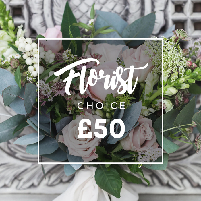 A lush, hand-tied bouquet sits against a subtly blurred carved-stone backdrop, the kind of composition you might see displayed near Mill Hill Broadway or carried home after a visit to the local market. Prominent soft blush pink roses form the heart of the design, their unfurling petals suggesting romance and quiet sophistication. Around them, abundant dusty blue-green eucalyptus leaves spread in cool fans, their rounded shapes and faint, cleansing scent providing a soothing counterpoint. Bright white clusters-likely snowberry or hypericum-add sculptural dots of light, while delicate sprays of tiny white waxflower or astrantia float through the stems, creating an airy, garden-picked impression. Small deeper pink and burgundy florets nestle in the mid-layer to give gentle contrast and dimensionality, and slender green-and-white flower spikes reminiscent of snapdragon peek from the left and right to add vertical movement. At the base, a soft cream fabric ribbon ties the stems in a simple, elegant knot that emphasizes the arrangement's bespoke, hand-assembled character. Overlaying the bouquet in the photograph is a clean white frame with text identifying this as a 'Florist Choice' priced at £50, a curated option often selected by customers seeking fresh seasonal value. As a Mill Hill florist, Flowers Mill Hill would describe this bouquet as tactile and fragrant-a composed yet relaxed bouquet perfect for birthdays, housewarmings, or quiet celebrations close to home.