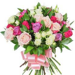 This radiant, hand-arranged bouquet reads like a tender love note in flowers, crafted with care and attention to balance and texture. At its heart are large classic roses in creamy white and pale pink, some petals unfurled into ruffled, velvety cups while others remain in tight, elegant bud form, creating a language of unfolding affection. Interspersed for contrast are hot fuchsia roses that give confident, joyous punctuation and a few soft lavender roses that introduce a cool, gentle whisper of colour. Smaller spray roses-ivory with hints of pale yellow-are tucked throughout, their dainty clusters adding fine detail and the impression of abundance. Dark, glossy leaves, probably ruscus or salal, are woven through the blooms, their rich green sheen providing a crisp counterpoint to the pastel and jewel tones and helping the arrangement sit with polished fullness. The stems are bound at the base and swathed in a wide, lustrous baby-pink satin ribbon tied in a generous bow; the ribbon's silky loops and trailing tails bring a finishing touch of refinement and feminine grace. As a local Mill Hill florist I imagine delivering this to a home near The Ridgeway or Mill Hill Village, where it will arrive fresh and fragrant, quietly announcing celebration and comfort. Prepared by Flowers Mill Hill with the same eye for composition we use across our deliveries, this bouquet suits birthdays, romantic surprises, Mother's Day, or as a beautiful thank-you gift that reads as both elegant and heartfelt.
