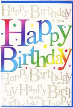 In this scene, a colourful birthday card is shown as if waiting on the counter at Flowers Mill Hill, ready to be tucked beside a fresh bouquet for local delivery. Dominating the card front, the words "Happy Birthday" are printed in generous, softly rounded letters that glow with a multi-coloured gradient. Each letter transitions through a sequence of shades-beginning with bold reds and berry pinks, moving into jewel-like purples and blues, then gliding into turquoise, grassy greens, and gentle sunshine yellows-creating a rainbow band that suggests the playful energy of balloons bobbing above a party in Mill Hill Park. The colours within each letter are carefully shaded, adding a sense of dimension and inviting the eye to linger. Behind the main text, a layer of delicate cursive writing fills the background completely, repeatedly spelling out "Happy Birthday to you" in fine, metallic gold script. The loops and swirls of the handwriting form a subtle pattern, almost like decorative filigree, and they catch the light with a soft sparkle that contrasts beautifully with the bold colour blocks in the foreground. Occasional tiny dots and stars in coordinating colours are scattered across the design, giving a light confetti effect that enhances the festive character of the card. The cardstock appears smooth and of good weight, finished with a light sheen that makes both the colours and gold details stand out without looking overly glossy. Overall, the mood is bright and affectionate, an ideal card to pair with a fresh, seasonal arrangement delivered around Mill Hill Broadway station, the quiet residential roads off Hale Lane, or the leafy avenues surrounding local schools for a birthday that feels genuinely cherished.