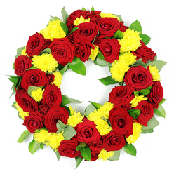 This image shows a meticulously crafted funeral wreath, its circular form resting against a bright white background that enhances every nuance of colour. The wreath is composed primarily of deep red roses, their petals full and velvety, unfolding in classic spirals that speak of love, honour, and deep respect. The roses are interwoven with numerous yellow chrysanthemums, whose smaller, multi-petalled heads resemble tiny bursts of sunshine, adding light and a gentle cheerfulness without diminishing the wreath's solemn tone. The interplay of rich red and bright yellow creates a measured contrast, offering comfort and hope alongside remembrance. Lush green foliage supports and frames the flowers, with shiny dark leaves and touches of lighter, almost silvery greenery that recall eucalyptus or similar foliage, contributing both structure and softness. Together, the flowers and greens form a complete, unbroken circle with an empty centre, a deliberate shape chosen to symbolise eternity, continuity, and the enduring nature of the bonds we carry in our hearts. The lighting is soft yet clear, casting no harsh shadows and allowing each petal edge and leaf vein to be visible, as though one could almost reach out and feel the different textures. This kind of wreath would be at home in a quiet chapel in Mill Hill or placed beside a memorial along one of the area's tree-lined avenues, providing a thoughtful and composed expression of sympathy, ideal for families seeking a meaningful floral tribute that reflects care, craftsmanship, and local sensitivity.