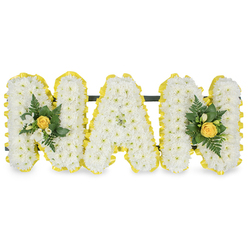 Softly poetic and intimate, this floral tribute reads as a cloud of white chrysanthemums shaped into the word MAM, each letter densely packed to create a velvety surface that absorbs the soft studio light and seems almost tactile. The arrangement is bookended by two furled, buttery yellow roses that sit within small accent clusters of delicate white freesia and deep green, glossy foliage - a pairing that suggests both tender memory and sunlit comfort. Bright yellow ribbon pleating runs around every letter's perimeter, folding and catching light to give a neat, uplifted edge that accentuates the crisp letter contours; beneath the top edges a slim dark support bar keeps the letters aligned for standing display. You can almost smell the gentle, green chrysanthemum scent mingling with the faint honeyed perfume of freesia, while the fern fronds and smooth leaves add a cool, herbaceous undercurrent. Designed with the quiet craftsmanship of a local Mill Hill florist, this tribute would suit a small chapel service or a graveside gathering at Mill Hill Cemetery or a nearby church hall, offered with the same care we bring to deliveries around Mill Hill Broadway and Mill Hill Village. At Flowers Mill Hill we often make pieces like this for families who want an intimate, personal homage - white for purity, yellow for warmth - a balanced expression of love and remembrance that invites reflection and a gentle sense of solace.