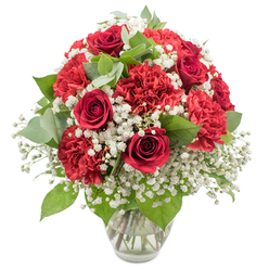 A richly textured bouquet of red and white flowers is arranged with expert care in a clear glass vase, photographed against a pristine white backdrop that highlights its colours and structure. Dominating the arrangement are deep red roses, their velvety petals folded into elegant spirals, each flower poised between bud and full bloom, evoking quiet intimacy and enduring romance. Nestled among them are plush red carnations, their densely ruffled petals creating soft, rounded forms that lend volume and a slightly playful, feathery texture to the design. Laced through the bold reds is a delicate veil of white baby's breath, countless tiny blossoms gathered in loose, airy sprays that add brightness and an almost dreamlike softness. Tucked in between the blooms are slender stems of greenery, including dark green rose leaves and rounded eucalyptus foliage in a muted, silvery-green tone, offering subtle contrast and a hint of woodland freshness, much like a peaceful stroll through Mill Hill Park. The bouquet forms a graceful, domed silhouette, designed to look beautiful from every angle, whether placed at the centre of a dining table near Mill Hill East or on a reception counter along Lawrence Street. The clear glass vase keeps the focus on the flowers while revealing the straight, clean stems and clear water inside, a quiet testament to professional preparation. The overall atmosphere is tender and celebratory, suitable for anniversaries, Valentine's surprises, heartfelt thank-you gifts, or simply bringing a touch of classic romance into a Mill Hill home with the timeless combination of red roses, red carnations, and white baby's breath.