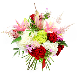 This image shows a sumptuous, professionally hand-tied bouquet set against a pure white background that highlights each colour and curve. Several deep crimson roses command attention at the centre, their velvety petals tightly layered to create a sense of depth and classic romance. Intertwined with them are pink lilies in different stages of bloom: some blossoms are wide open, revealing soft, lighter pink centres and prominent stamens dusted with pollen, while others remain in slender, closed buds, promising a slow reveal of beauty and gentle scent over the coming days. Encircling these focal flowers is a cushion of rich, ruffled white blooms, reminiscent of hydrangea heads or generous carnations, giving the bouquet a voluminous, cloud-like base that feels as soft as it looks. Nestled centrally, a bright lime green cluster of finely textured dianthus adds a modern note and a burst of freshness, echoing the vibrant greenery you might see on a walk across Mill Hill Park or along Daws Lane. Delicate, feathery spires of pale pink astilbe rise lightly above the main flowers, lending airy movement and a whisper of wild meadow charm. Scattered through the bouquet are tiny blossoms of fuchsia and lavender, offering hints of playful colour and inviting the eye to linger. Dark green foliage, glossy and healthy, peeks between petals and blooms, framing the design and providing natural contrast. At the base, the visible stems are neatly aligned and hand-tied with a slim, deep red satin ribbon, signalling the skill and care behind the arrangement from Flowers Mill Hill. Overall, the bouquet gives an impression of joyful sophistication, ideal for marking special moments, from milestone birthdays to heartfelt thank-yous, delivered across Mill Hill and the surrounding area.