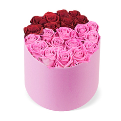 As a local Mill Hill florist, I see this arrangement as modern romance expressed in living color. The roses form a clean, intentional composition, with a deep arc of crimson red at the top cradled by surrounding pinks. The soft pink hatbox adds a tactile softness-velvet under the fingertips-enhancing the sense of luxury. The blooms themselves wear a luscious, open-face look, their petals curling gently inward in protective spirals, creating depth and quiet drama. The design remains neatly balanced: no foliage competes with the blooms, and each stem is spaced to convey quiet abundance rather than crowding. What I love is the instant uplift-the light, symmetry, and the joyful interplay between red and pink-making it ideal for marking a special day, from a milestone anniversary to a beloved birthday, or simply to surprise someone special. A gentle scent lingers, a promise of bloom even as the room fills with warmth. Available for same-day delivery across Mill Hill and surrounding areas, this gift box offers a refined moment that brightens any space, a timeless gesture of love wrapped in luxury. It's the kind of piece to gift when you want to say "you are cherished" with grace and lasting beauty, a small luxury that resonates beyond the moment.