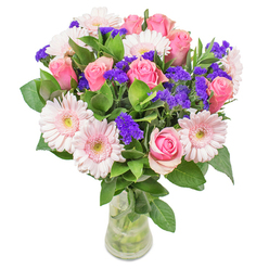 In my Mill Hill workshop, arranging these flowers is a pleasure-each stem is selected with care, reflecting not just floral artistry but the welcoming spirit of our North London neighbourhood. The focal point is the interplay between gentle blush Gerbera daisies and impeccably formed pink roses, their tones blending seamlessly, warmed by soft morning light that spills across the vase. Rich violet statice adds intriguing depth, its lively punctuation ensuring the color story remains vibrant yet soothing. The bouquet is anchored by a lush layer of deep green leafage, cool to the touch, reminiscent of paths winding through Mill Hill Park in spring. Placed in an understated glass vessel, the arrangement glows from within-capturing the optimism of a peaceful Mill Hill morning. Designed to inspire, it easily lifts the mood of any space: a stylish gift for a new home on Hale Lane, a thoughtful get-well gesture, or simply a centerpiece that embodies careful craftsmanship and quiet happiness. Each component is chosen to express positivity, with every brush of petal, every spark of colour, and every subtle fragrance crafted to evoke a little more joy, care, and local pride.