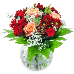 Imagine cradling this exquisitely fresh bouquet prepared by Mill Hill's leading florists, as soft light illuminates the velvet red roses and rich red chrysanthemums at its heart. These bold blooms encircle tender apricot and salmon roses, offering a gentle glow that softens the intensity much like the natural light filtering through the trees at Mill Hill Park. Wisps of delicate gypsophila drift among the flowers, their presence as subtle and enchanting as a morning haze over the Ridgeway. The composition's stems, set in a clear glass vase, are surrounded by lush emerald leaves reminiscent of the flourishing green spaces along the Avenue. Each element is selected with care-the tactile contrast of the velvety petals, the airiness of gypsophila, and the hearty freshness of the foliage lend depth and dimension. The scent is quietly uplifting: a blend of freshly cut greens and sweet, classic roses, invoking tranquil memories of walks through local gardens or visits to the farmers market. Crafted to celebrate love, friendship, or significant milestones, this harmonious bouquet brings an effortless sophistication to any Mill Hill setting. Whether placed as a centrepiece for an intimate dinner, a cheerful addition to a welcoming hallway, or a heartfelt delivery to a friend celebrating in NW7, it radiates natural beauty and local craftsmanship in every detail.