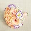 Photographed from above in gentle daylight, this exquisite bridal bouquet captures the harmony of classic floral artistry with the spirit of Mill Hill's vibrant community. The round, compact arrangement is anchored by sumptuous, fully opened roses in soft peach and apricot, their unfurling petals revealing blush pink undertones that warm the entire design. Intertwined with these are spotless white Lisianthus, each petal tipped in a delicate lavender-violet hue-an unexpected flourish as charming as the gardens found along Sanders Lane. Wispy crowns of Baby's Breath wrap the bouquet in a cloud-like softness, enhancing the dreamy, romantic aura. The hand-tied stems are elegantly cloaked in a smooth, light peach ribbon, with a subtle pearl bead detail that glimmers with understated sophistication. This bouquet, designed for weddings, bridesmaids, or stylish special events in Mill Hill, showcases favorite floral choices in a pastel palette that feels equal parts timeless and contemporary. Every aspect-from the artful composition to the considered finishing touches-speaks to the dedication and creativity of Mill Hill's local florists, offering inspiration and a heartfelt connection to North London life with every petal, scent, and texture.
