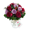 A vibrant, lovingly arranged bouquet of fully bloomed roses in a rich duet of deep crimson and soft lavender, presented like a warm embrace. The round, densely packed head shows velvety red and burgundy roses whose unfurling petals catch the light, alternating with delicate lilac and dusty purple roses that soften the composition. Interspersed among the blooms are small clusters of bright red-orange hips, lending a rustic, berry-like texture that offsets the roses' satin smoothness. Lush dark green foliage-likely Ruscus or Salal-frames and threads through the arrangement, giving depth and a cool, leafy counterpoint to the warm floral tones. The bouquet sits in a rounded mercury-effect glass vase with an antique silvered mottle, its reflective surface shimmering subtly and echoing the bouquet's romantic mood. Natural raffia is tied simply around the vase neck, and a small rectangular white gift tag hangs forward, blank of logos, ready for a handwritten note. Soft, even daylight from a studio setup highlights the petals' sheen and the foliage's glossy veins against a clean, brilliant white background, making each hue read distinctly. The overall feeling is intimate and refined-perfect for an anniversary, a quiet apology, or a heartfelt thank-you-and suggests freshness and careful craftsmanship from a local Mill Hill florist. The piece evokes the hush of early morning deliveries along The Ridgeway or the thoughtful charm you might find strolling past Mill Hill Village, a bouquet meant to comfort, celebrate, and be unwrapped slowly by someone you love.