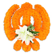 A reverent, handcrafted floral Khanda sits against a clean white backdrop, every detail rendered in warm orange and cool white. The classic Sikh emblem - a circular chakkar encircled by two crossed kirpans and topped by a central double-edged khanda - is sculpted from hundreds of small, densely packed bright orange marigold blossoms. Up close the marigolds read like a velvety, sunlit carpet: each pompom petal catches the light and casts soft, tactile shadows that give the symbol a three-dimensional warmth. Where the kirpans intersect a compact cluster of large white lilies has been placed with quiet dignity; at least two lilies are fully open, their satin petals curving back to reveal pale green and yellow stamens, while several tighter lily buds hint at gradual bloom. Sprigs of glossy green foliage nestle around the lilies, and fine sprays of tiny white gypsophila thread through the orange, softening edges and lending a breath of innocence to the composition. A delicate drop shadow beneath the arrangement suggests it is freestanding, carefully set on a tabletop or pedestal, lit by soft studio light that emphasizes texture without harsh highlights. The overall mood is devotional and celebratory - the warmth of the marigolds balanced by the lilies' serene purity - suitable for temple decorations, festival displays, or memorial tributes. As a local Mill Hill florist I picture this piece placed near Mill Hill Broadway or Mill Hill Village during Vaisakhi or Gurpurab, where its colour, scent, and symbolism would draw the eye and quiet the heart, offering both visual splendour and spiritual comfort.