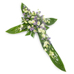 A solemn floral cross photographed from a gentle overhead angle against a clean white background, its silhouette defined by broad, glossy tropical leaves-the kind of Ti or similar foliage with visible veins and a waxy sheen that catch the light and form the cross's arms and centre. Nestled into that verdant foundation is a concentrated spray of soft white and creamy ivory lisianthus, their ruffled petals and partly closed buds offering a tender, cloud-like texture. Interspersed among the lisianthus are small, rounded white chrysanthemums that lend brightness and a compact, cushiony feel, while delicate sprays of pale lavender aster or limonium scatter like whispers of colour, creating gentle depth and a cool contrast to the warm ivory tones. Finer green filler foliage is woven through the clusters, softening edges and adding subtle movement, so the design reads as both structured and naturally tender. The even, soft lighting gives the whole composition a calm radiance, enhancing the sheen of the leaves and the creamy translucence of the blooms, and the overall impression is one of quiet dignity and reverence. This arrangement is clearly intended as a sympathy or memorial tribute-appropriate for placement at a funeral, wake, or church service-and conveys peace, respect, and remembrance without ostentation. As a Mill Hill florist might arrange for a family gathering at a local chapel or graveside near Mill Hill Broadway, the cross's restrained palette and careful craftsmanship speak to thoughtful condolence and the hope of comfort in times of loss.