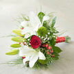 This image captures a romantic bouquet placed at a diagonal angle on a neutral, off-white fabric that subtly echoes the texture of fine linen, letting the colours of the flowers truly shine. Dominating the arrangement are several opulent white oriental lilies, some open wide with their trumpet-shaped petals flaring outward, others standing as closed green buds that promise future blossoms. The open lilies display gently rippled edges, and the centers are marked with delicate reddish speckles that lend character and depth. Near the core of the bouquet, a single dark red rose unfurls in a tight, velvety spiral, radiating a sense of passion and timeless love that would feel perfectly at home in wedding photos taken around Mill Hill or nearby green spaces like Arrandene Open Space. Two plush, ball-shaped green trick dianthus blooms nestle among the lilies and rose, their fuzzy, almost moss-like texture offering a fresh, modern accent against the sleek lilies. Throughout the arrangement, slender stems of baby's breath carry clusters of minuscule white flowers, forming a light, airy veil that softens and unifies the entire composition. Small, shining red hypericum berries dot the greenery, their smooth skins reflecting the soft ambient light and echoing the rose's rich hue, adding a gentle, celebratory sparkle. A variety of foliage frames the flowers: sturdy, dark leaves ground the design, while thin, grass-like stems sweep outward in elegant curves that give the bouquet movement and structure. At the lower right, the exposed stems are neatly bound with a luxurious red satin ribbon, wrapped snugly to hold everything together and finished with a subtle sheen. The bouquet feels both classic and contemporary, ideal for Mill Hill brides, anniversary celebrations, or intimate romantic gestures delivered to homes along Mill Hill Broadway and the surrounding lanes.