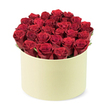 From Flowers Mill Hill, this luxurious and elegant boxed bouquet is a celebration of red romance. Dozens of deep red roses, each bloom velvety and perfectly furled, are densely packed into a round, cream-colored box with a smooth matte finish-reminiscent of a chic hat box crafted for premium delivery. The roses fill the cylindrical container completely, creating a lush dome that rises slightly above the rim, while narrow ribbons of green foliage peek between the blossoms, adding freshness and natural contrast. The composition is presented from a slightly elevated three-quarter angle, set against a clean white background to keep the focus on the flowers and their couture packaging. The scent of rose lingers softly, hinting at the emotion behind the gift. This arrangement embodies love, passion, and romance-an ideal centerpiece for anniversaries, Valentine's celebrations, or as a luxurious expression of appreciation. In Mill Hill and surrounding districts such as Mill Hill Broadway and Daws Lane, this premium boxed bouquet is typically available with same-day delivery, ensuring a thoughtful moment arrives promptly. The box's pale ivory color, its matte finish, and the careful hand-placing of each bloom reveal a craftsman's touch and a commitment to quality that Mill Hill customers have learned to trust. It's the kind of gift that remains a keepsake long after the flowers fade, a quiet testament to romance delivered with elegance.
