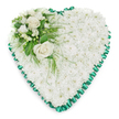 A classic heart-shaped sympathy arrangement sits against a stark white background, its calm beauty and careful construction immediately apparent, as if prepared for a quiet ceremony in Mill Hill. The heart is fully covered with tightly packed white chrysanthemums, their many small petals layering together to form a thick, cushioned blanket of blooms. This pure white base suggests peace, innocence, and gentle remembrance, offering a sense of calm and comfort. The chrysanthemums are arranged with precision so that the surface appears smooth and even, with just enough texture to catch the light in soft, subtle shadows. Tracing the perimeter of the heart is a pleated emerald green satin ribbon. The ribbon is ruffled into delicate scallops, creating a defined border that frames the flowers and adds a graceful contrast to the white petals. Its slightly glossy finish introduces a sophisticated touch, similar to the thoughtful details that might be seen in a well-organised funeral service near Mill Hill Broadway. In the upper left curve of the heart, a focal spray of flowers introduces depth, contrast, and emotional emphasis. Two open white roses form the centre of this cluster, their petals gently spiralling outwards in layered whorls that symbolise enduring love and unspoken affection. Around them, smaller white flowers-likely freesias or comparable delicate blooms-add softness and a hint of fragrance. Sprays of greenery, from broad, shiny leaves to fine feathery fronds, cradle the blooms and trail lightly over the chrysanthemum base, blending the cluster into the heart. The entire arrangement feels serene, respectful, and heartfelt, a fitting floral tribute to send to a funeral or memorial in Mill Hill to honour a loved one and offer comfort to those who are grieving.