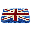 This photograph captures a large Union Jack coffin tribute crafted entirely from fresh flowers, arranged with the precision and care of an experienced local florist in Mill Hill. The piece is rectangular and slightly raised, giving it a soft, padded appearance, as though a fabric flag has been translated into blooms. A dense layer of deep blue chrysanthemums forms the backdrop, their compact heads pressed closely together to create an uninterrupted field of colour. Resting on this are crisp white stripes of blossoms, running up-and-down and side-to-side in perfect alignment to depict St George's Cross, the flowers full and cloud-like yet trimmed into sharp, straight edges. Diagonal bands of rich red flowers, likely carnations, cross the arrangement to represent St Patrick's Cross, each red stripe edged meticulously with fine white borders to preserve the flag's intricate pattern. The colour palette-patriotic red, white, and blue-is vivid but softened by the natural texture and gentle sheen of fresh petals. Along the bottom edge, a wide blue satin-style ribbon has been artfully pleated, echoing the blue blooms above and framing the tribute with a refined, ceremonial touch. The overall effect is of solemn beauty and national pride, perfectly suited to a funeral service or memorial gathering in Mill Hill, whether at a local church or crematorium on the outskirts of the area. You can almost sense the quiet murmur of family and friends as they pause before this floral flag, the subtle fragrance of freshly cut flowers offering a moment of peace and reflection during a final farewell.
