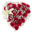 This image shows a meticulously crafted heart-shaped bouquet composed almost entirely of deep crimson roses, each petal velvety and layered from tight buds to fully opened blooms, forming the rich core and silhouette of the heart. Interwoven between those roses are soft clusters of tiny, star-like white baby's breath (Gypsophila), their cloud-like sprays filling gaps and tracing a delicate halo that lightens the intense red mass. At the upper left curve of the heart a single, sculptural white lily unfurls-broad, pristine petals edged with a whisper of cream and a visible center with warm yellow-orange stamens-providing a calm, elegant counterpoint to the passionate roses. The arrangement rests against a clean white background that isolates its colours and textures, letting the deep reds and stark whites read clearly to the eye. In describing this for someone who cannot see it, imagine the cool velvet of a rose petal brushed by a faint scent of sweetness, countered by the green, faintly spicy perfume of the lily's throat; the gypsophila adds an airy, almost breath-like quality between each heavier bloom. The heart shape is exact and reassuring, its edges softened by the tiny white florets while the lily punctuates the composition with serene purity. This bouquet carries a gentle message-romantic and sincere-suitable for anniversaries, valentine gestures, or a refined tribute when words are not enough. A Mill Hill florist would present it with careful wrapping and a tenderness that reflects local care and floral craftsmanship familiar to the neighbourhood.