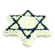 The photograph shows a beautifully crafted Star of David funeral tribute composed entirely of fresh flowers, standing out sharply against a plain white background. The star's outline is unmistakable, formed from tightly clustered chrysanthemums and similar multi-petaled blooms that give the whole piece a dense, cushioned texture. A wide band of pristine white flowers runs along the outer edge, sharply tracing the six points of the Magen David and giving the design a clean, luminous frame. This same white continues into the central hexagon and the six small triangles that point inward from each tip of the star, creating a bright, tranquil core. The two interlocking triangles that define the traditional Jewish symbol are filled with rich navy blue blossoms, their dark hue clearly marking out the intersecting shapes and recalling the blue stripes of the Israeli flag. The arrangement feels balanced and considered, its symmetry and neat edges reflecting the skill of a professional florist familiar with Jewish funeral customs in Mill Hill and the surrounding North West London areas. You can easily imagine this tribute delivered for a funeral or memorial at a local synagogue or to a house near Mill Hill Circus for shiva, where it would serve as a central, respectful gesture from family and friends. The piece carries a quiet emotional weight; without any printed words or additional adornments, the floral star itself becomes the message, offering comfort, solidarity, and a visible expression of Jewish identity and remembrance for the departed.