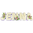 A deeply personal memorial piece spells the name JENNA in five bold, three-dimensional letters crafted from a dense carpet of creamy white chrysanthemums-or similar small, snow-white florets-set against a clean white backdrop. Each letter reads with soft, cloud-like volume, the tiny petals building a comforting, tactile surface that catches the light like freshly fallen snow. A narrow ribbon or band of deep purple follows the inner edges of every letter, offering a restrained, elegant outline that gives definition without overwhelming the gentle white. Carefully placed accent clusters lend warmth and quiet colour: blush-pink and lavender spray roses, a few pale cream or buttery yellow buds, and fronds of feathery green fern tucked into the curve of the 'J', the lower bar of the first 'N', and the upper right of the concluding 'A'. Thin, dark support bars run behind the letters, subtly joined to keep the tribute steady and display-ready for a chapel, wake or crematorium setting. There is a faint floral perfume-powdery chrysanthemum with the soft sweetness of spray roses-that suggests handcrafted freshness. The arrangement feels composed with the kind of care offered by small neighbourhood florists in Mill Hill, where customers sometimes request personalised name tributes for services at local chapels near Mill Hill Broadway or quiet ceremonies in Mill Hill Park. Light plays gently across the petals in soft, even illumination, accentuating both the serene white and the discreet purple trim; the overall effect is respectful, intimate and dignified-a heartfelt floral farewell that reads clearly from a distance while rewarding close inspection with delicate detail.