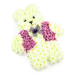 In this image, a charming teddy bear-shaped floral tribute appears almost like a storybook character brought to life in blooms, thoughtfully designed for a moment of farewell. The bear's plump, rounded body is densely coated in creamy white chrysanthemums, each flower placed so closely that the surface looks like downy fur. The petals are soft and frilled, creating a sense of depth and texture across the head, ears, arms, and legs. Subtle hints of ivory and pale yellow at the flower centers give the bear a warm, comforting radiance. On its face, two dark, button-style eyes and a little black triangular nose form a simple yet expressive look, while a delicate sweep of soft pink petals suggests a faint, gentle smile that feels both tender and protective. Across the chest, a bright waistcoat emerges from clusters of deep pink and magenta chrysanthemums, their richer tones bringing a heartfelt splash of colour. The vest is shaped with clear edges, echoing the neat tailoring of a real teddy's outfit. Positioned at the neckline is a small bow tied from sheer violet netting, its light, airy loops adding a playful yet respectful finish. The entire tribute stands out crisply against a pure white background, under soft lighting that highlights the freshness and symmetry of the flowers. Created with care for families in Mill Hill and the surrounding areas of Edgware and Hendon, this floral teddy suits children's funerals, baby farewells, or memorial gatherings where a symbol of innocence and love is needed, offering a gentle floral embrace at a profoundly emotional time.
